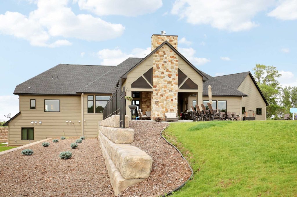 The back yard of a newly constructed house with new landscaping and new shrubs.