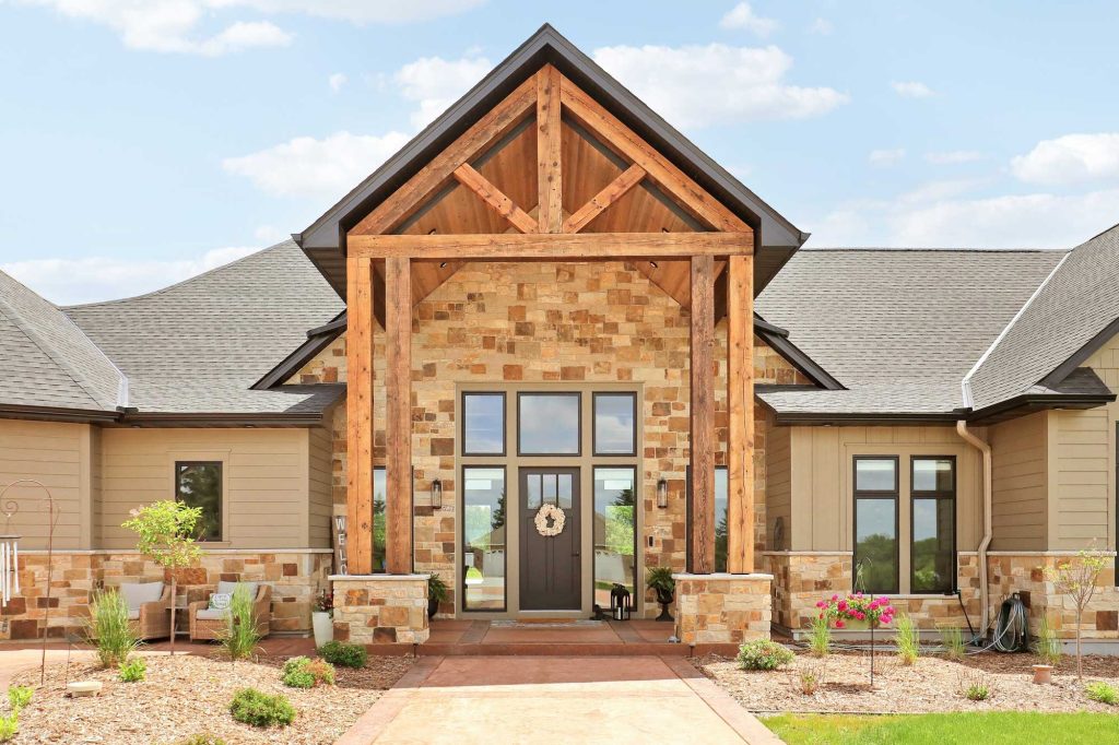 The front entrance of a new house with a brick front entrance and new landscaping and shrubs.