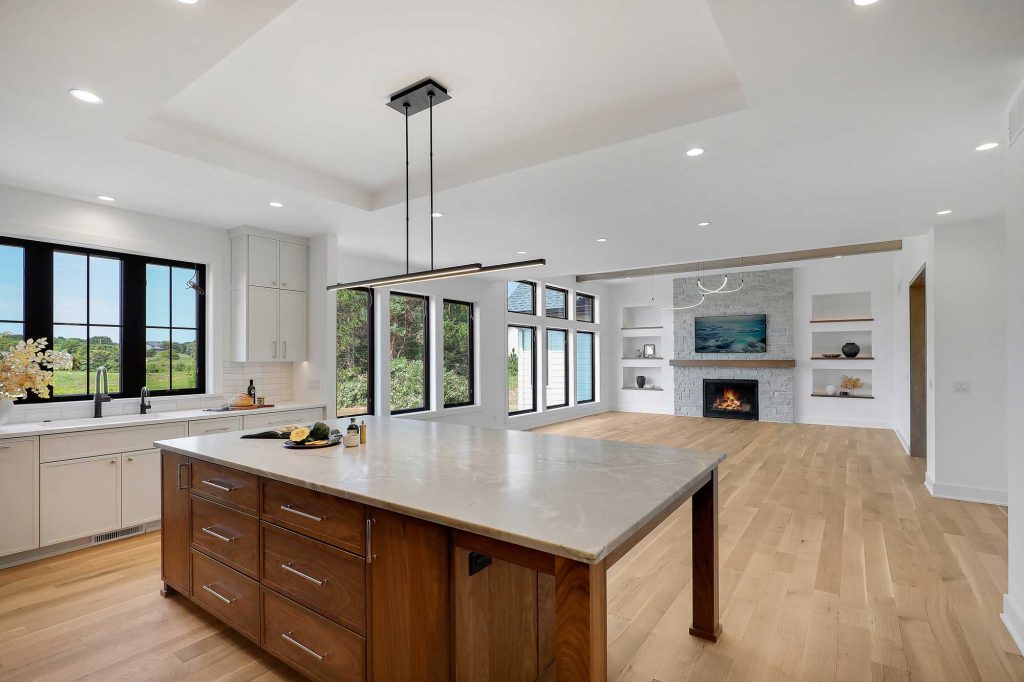 Kitchen view with the island, facing both a dining area and a living room with the built in fireplace. 3761 William Way Independence Mn 55359 36