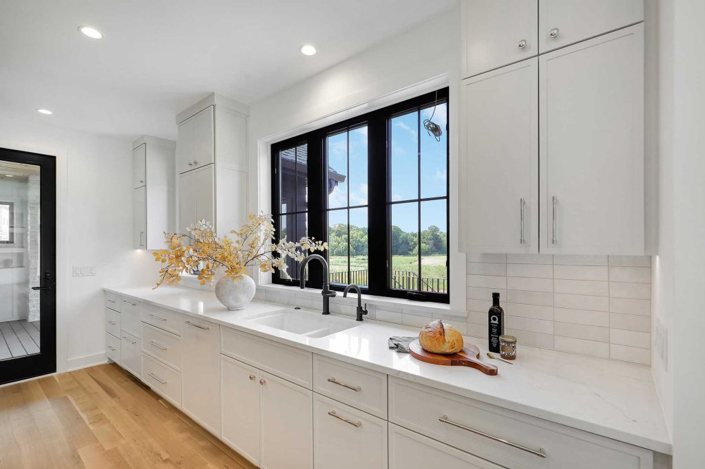 White kitchen, with white cupboards, white countertop and black framed window above the sink. 3761 William Way Independence Mn 55359 41