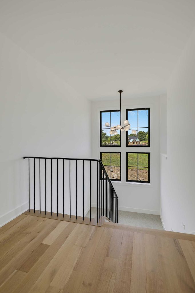 Stairwell going down to a split level and 4 big black framed windows. 3761 William Way Independence Mn 55359 88