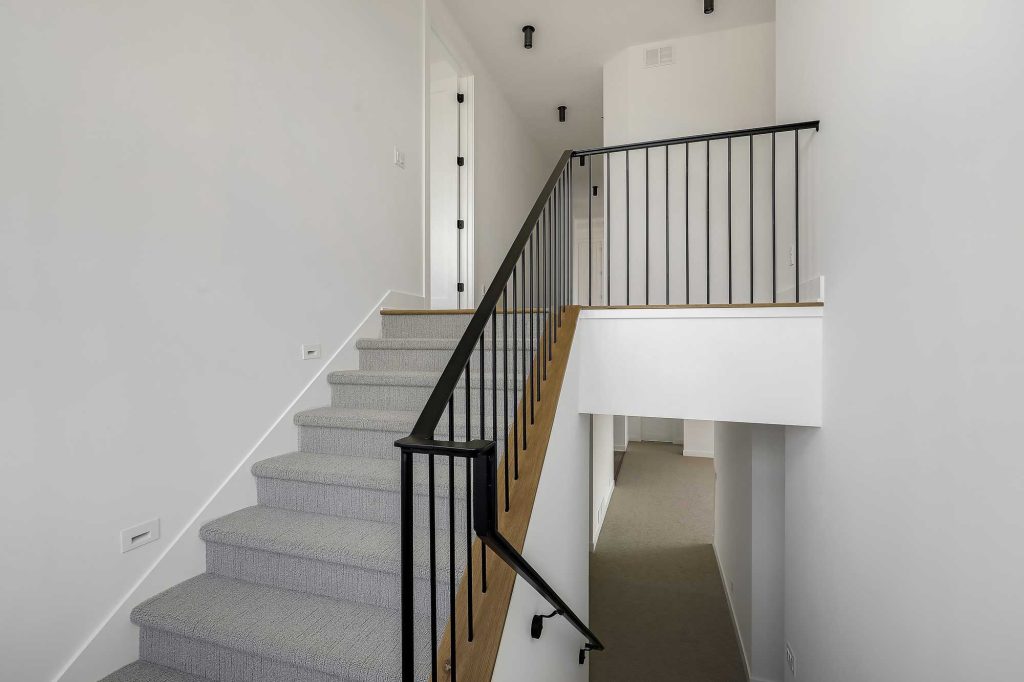 Stairs with gray carpet and a black rod iron railing. 3761 William Way Independence Mn 55359 91